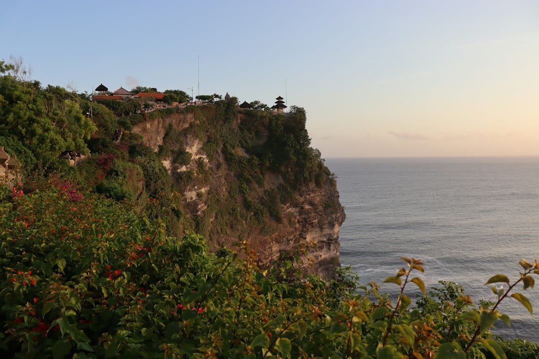 Uluwatu Temple perched on dramatic limestone cliffs overlooking the Indian Ocean at sunset