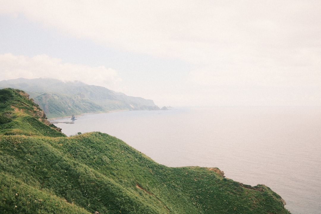 Batanes scenic coastal landscape with lighthouse and green hills