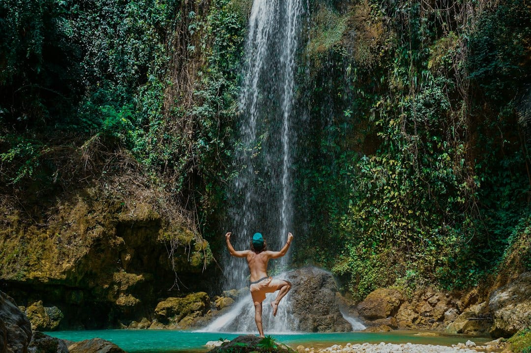 Adventurer canyoneering through turquoise waters at Kawasan Falls in Cebu