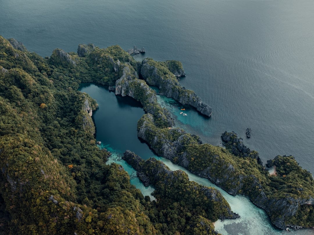 Kayaker inside El Nido's Big Lagoon surrounded by towering limestone walls