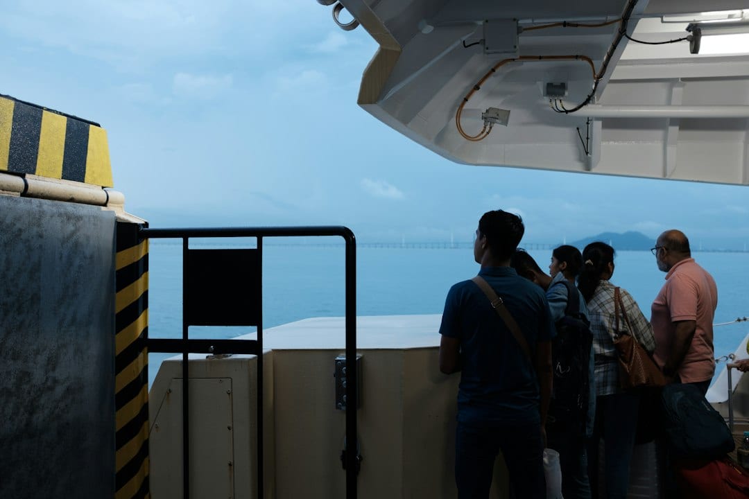 Passengers on the deck of a fast ferry cruising through tropical waters