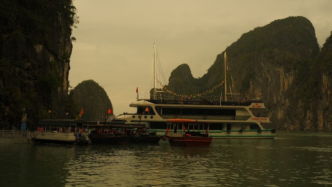 Traditional wooden junk cruise boat in Halong Bay with passengers boarding