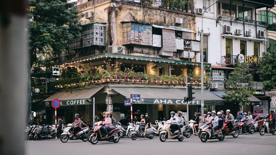 Busy street scene in Hanoi's Old Quarter with motorbikes and shops