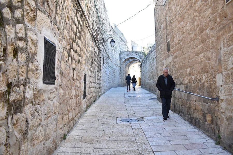 Pilgrims walking along ancient stone streets in Jerusalem's Old City