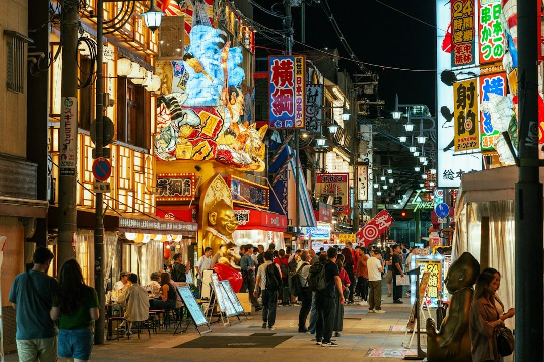 Osaka Dotonbori canal glowing in autumn evening with neon signs and street food stalls during a 2026 Japan fall trip