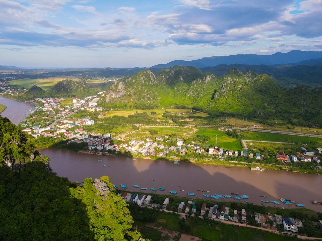 River flows through a lush green valley with mountains near Phong Nha