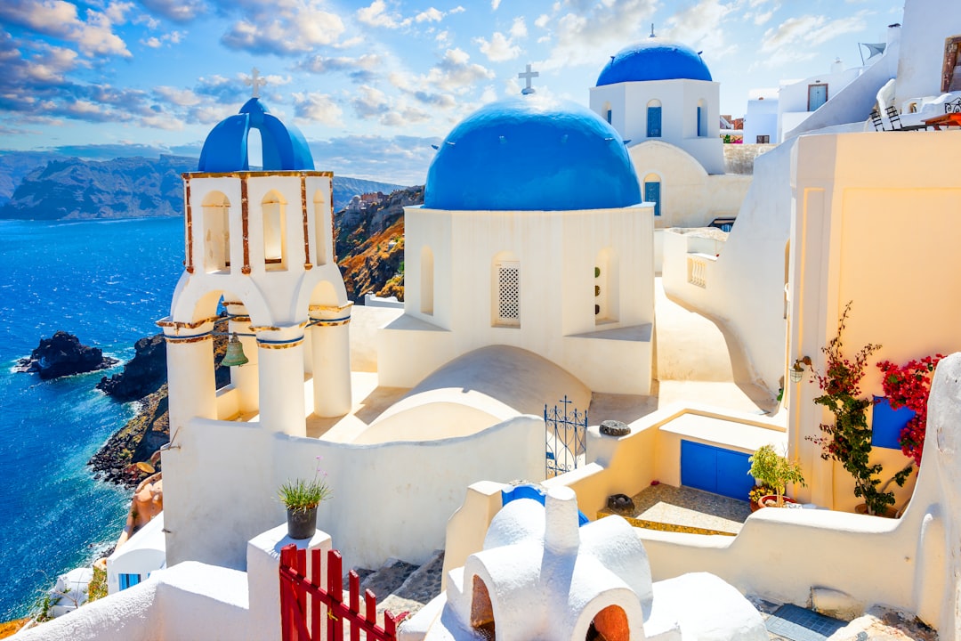 Santorini iconic white buildings with blue domes overlooking the caldera at sunset