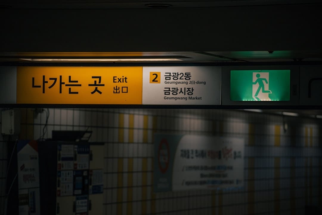 Seoul subway station interior with directional signage and passengers