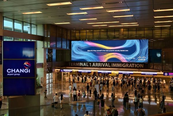 Singapore Changi Airport arrival hall with travelers and immigration signage