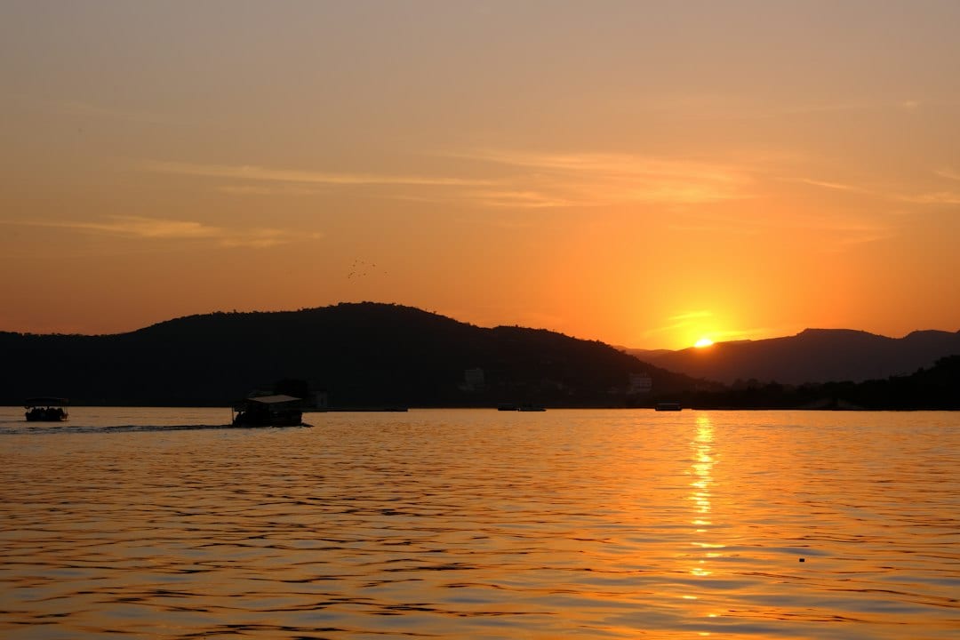 Udaipur City Palace reflected in Lake Pichola at sunset, Rajasthan