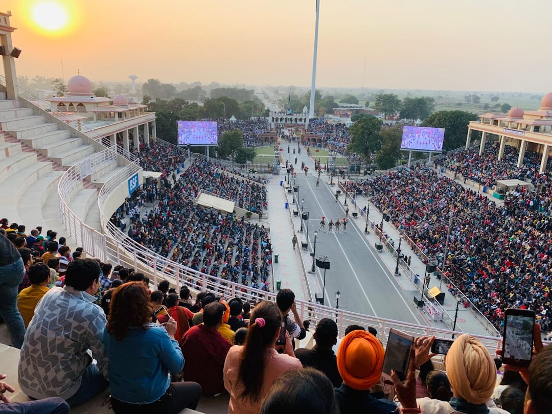Wagah Border ceremony at sunset with Indian soldiers in ceremonial uniforms marching before flag lowering