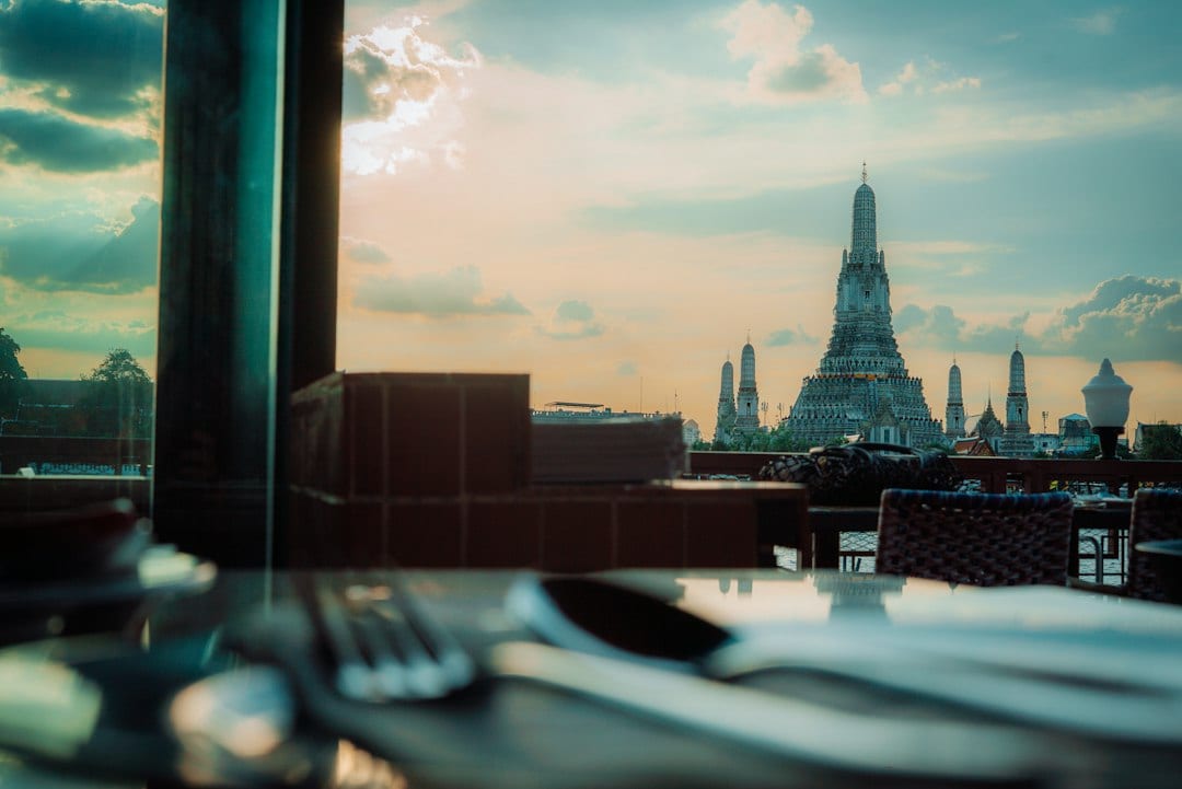 Wat Arun temple towers along the Chao Phraya River at sunrise
